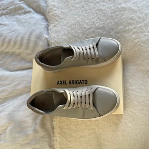 Axel arigato skor (grå) - Säljer mina knappt använda arigato skor, i färgen grå de är i storleken 42 men har några små defekter men annars som nya, nypris ligger på 1800kr säljer de för endast 800!!!! Kan skicka me postnord, fråga gärna om mer bilder