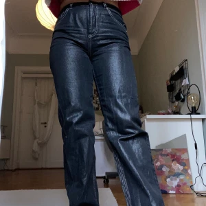 Svarta lackade jeans - Säljer skit najs top shop jeans som är lackade med vita sömmar. De är i bra skick då dom inte kommit till användning så mycket! 