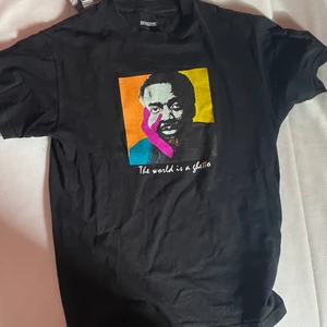 T shirt  - Säljer min t shirt. Köpt från någon affär i Stockholm. Säljer den för att den har blivit för liten. Storlek M. Texten är ”The World is a ghetto”. Säljs för 100 kr plus frakt 