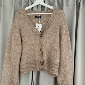 Stickad kofta med knappar - Jättemysig kofta från Bershka! Säljer pga aldrig använder. Den är helt oanvänd. Köpt från Asos. Originalpris 400 kr.