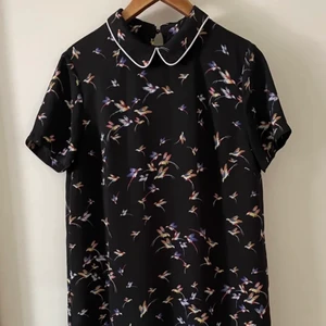 Klänning svart med tryck - A-line klänning i svart med tryck. Passar S/M. Längden 85 cm. I bra skick. Viskose och polyester