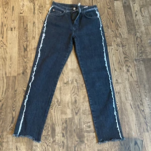 Weekday jeans - Superfina jeans från weekday i modellen Seattle med detalj på sidorna. Färgen är lite urtvättad svart/grå och detaljen på sidan är grå/vit. Tyvärr alldeles för små för mig redan vid köp så dessa har aldrig används. Passar nog de som är XS och midjestorleken är 26. Dem är fransade nedtill men är inte korta eller långa i modellen utan lagom långa för mig som är 167cm. Köptes för 500kr.