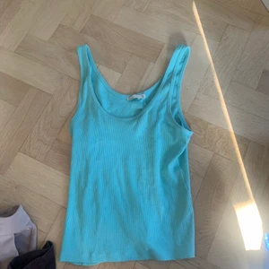 Linne - Ett turkost/blått linne från Nelly ! Använd fåtal gånger. Kommer inte till användning sitter väldigt fint och fint om man viker in det!❤️