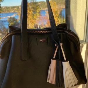 Guess väska  - Säljer min praktiska guess väska! Den är i väldigt fint skick med många fack. Köptes för 2000kr❤️‍🔥