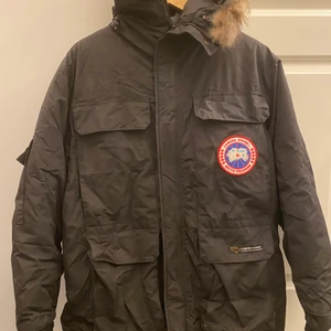 Canada goose - Extremt varm dunjacka från Canada goose. Stor i storleken, är xxs men passar stl M-L. Fin men tyvärr har hållaren till dragkedjan gått av, se bild,  dragkedjan är dock hel och den går att använda som vanligt. 