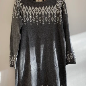 Julklänning med stenar - Grå stickad klänning från Holly & White by Lindex med vita detaljer och stenar. Långärmad och räcker ner till strax innan knäna på mig som är 165cm lång. Storlek M men är lite lösare i passformen. Nypris 799kr 