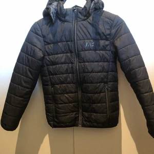 Everest svart tunn jacka med luva - Svart tunn Everest jacka. Strl 146/152.Avtagbar luva. Snygg! Bra som extra lager när det är kallt. Köparen står för frakten.