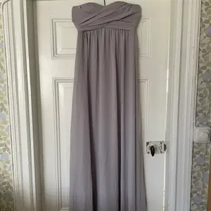 En helt oanvänd klänning från hm, storlek 34, ljusgrå och axelbandslös! Funkar till allt från bal till bröllop! Utgångspris 100kr. 