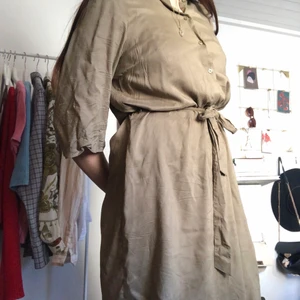 Knälång skjortklänning  - Jättesnygg skjortklänning som även passar toppen att bära öppen. Skön och luftig med band i midjan. Normal i storlek . (Behöver uppenbarligen strykas lite, men är använd max 5 gånger!)