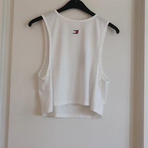 Vit topp Tommy Hilfiger stl M - En vit träningstopp från Tommy Hilfiger i storlek M. Fraktkostnaden tillkommer.
