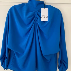 Blå blus från zara  - Helt ny blå blus från zara. Massa fina detaljer vid bröst och ärmslut. Dragkedja och knytning bak. Prislapp kvar, nypris: 359kr😊