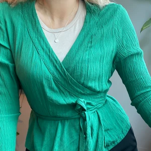 Grön omlottblus  - Grön omlottblus i viskos med knyt i midjan. Sparsamt använd, gott skick! Köparen står för frakten ✨
