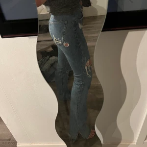 Jeans Pull&Bear - Skitsnygga jeans med slitningar och slits nedtill från Pull&Bear i storlek 34.