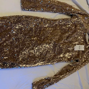 Paljett klänning -  Guldig klänning helt ny, storlek s 