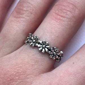 silvrig ring med blommor - Supersöt silvrig ring med blommor, aldrig använd!😊 ca 17mm i diameter! Frakt 10kr