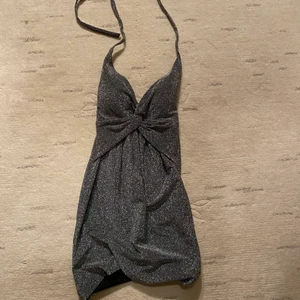 glittrig halterneck klänning - glittrig klänning perfekt till nyår! Vaddad vid brösten. Halterneck style. Passar xs och S. klänningen är öppen på ryggen. banden knyter man själv runt halsen, så klänningen är justerbar. ❤️