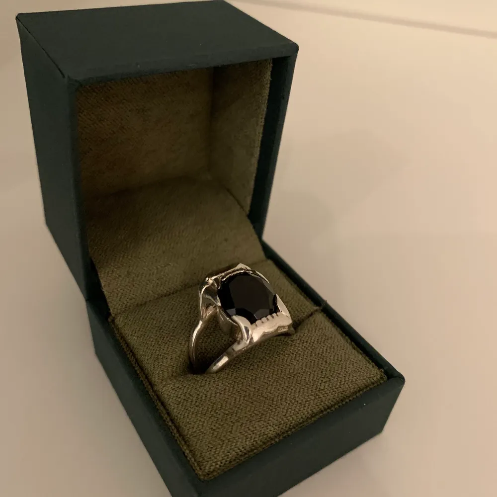 Populär ring i silver med svart sten från Maria Nilsdotter. Modellen heter jaw stone ring. Den är i väldigt gott skick samt nypolerad i butiken. Kvitto finns. Medföljer även original förpackning, box och påse. Nypris ca 5000. Accessoarer.