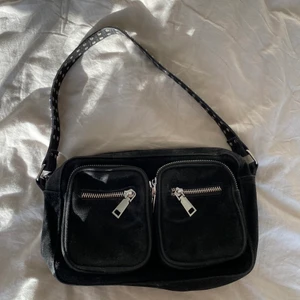 Väska - Säljer min svarta Noella väska från Two angels som jag inte använder längre. Perfekt storlek och i bra skick. 3 stycken fack inuti (två små och ett lite större med dragkedja). Skriv till mig privat om du är intresserad.