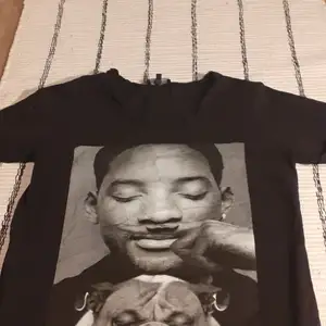A blak t shirt with Will Smith in black and White.