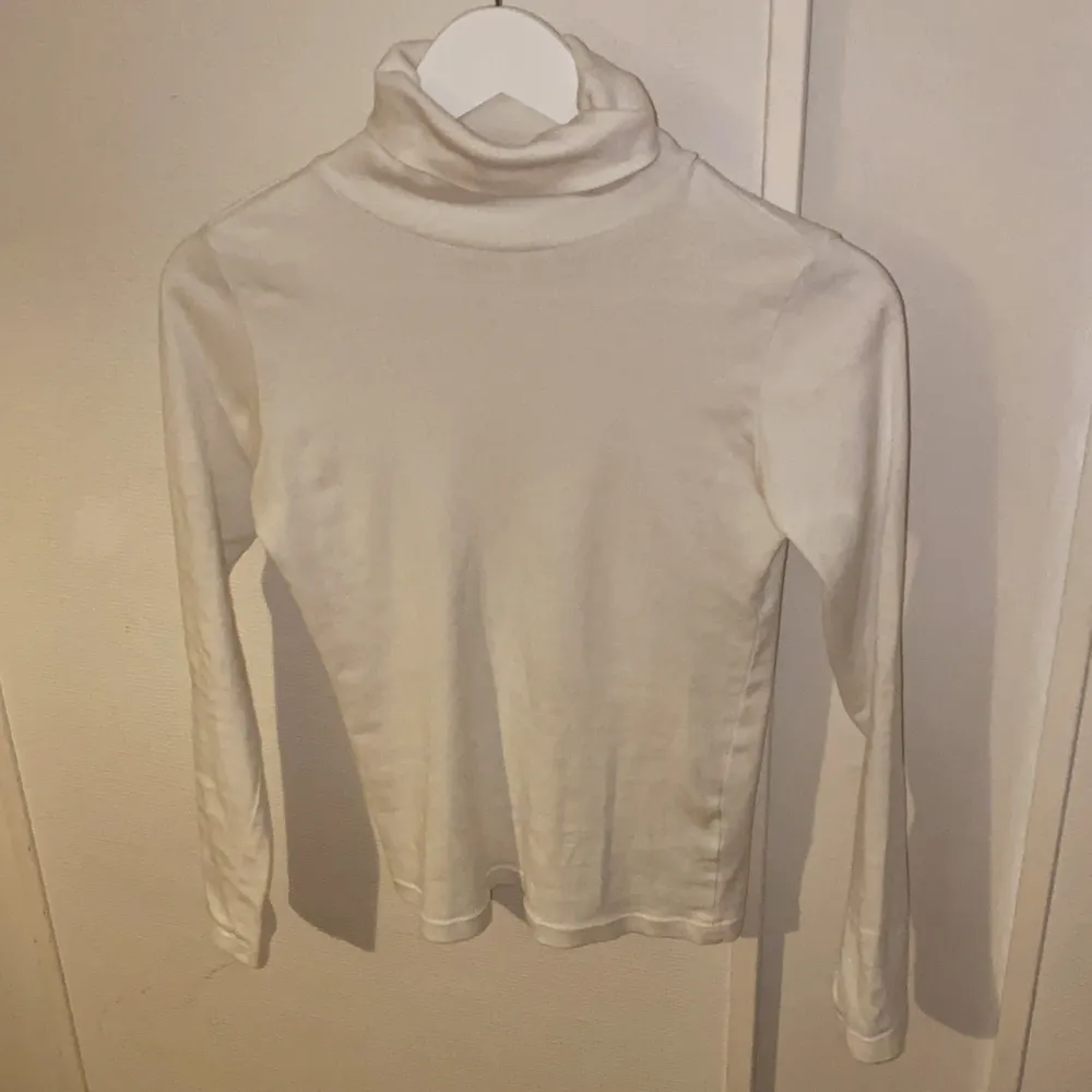 Vit polotröja från Åhlens. Säljer pga att jag har en exakt likadan i större storlek. Inte särksilt genomskinlig om man har rätt bh under, men såklart kan man se konturer från bh. Kan skicka tydligare bilder om så önskas. Säljes för 70kr köpt för 300kr. Neuletakit & Villapaidat.