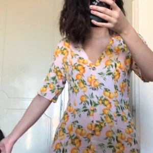Klänning - Somrig klänning med apelsiner. Endast använd två gånger så i väldigt bra skick och är otroligt skön! Säljer pga att jag köpte samma i svart. 