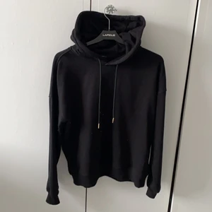 Svart Hoodie - Jag säljer min svarta hoodie som blivit för liten, den är helt svart och använd cirka 5 gånger. Den är i storlek L men sitter ganska tajt så den är som en S/M
