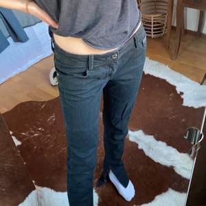 Svarta lågmidjade jeans med slits nertill i storlek W27/28