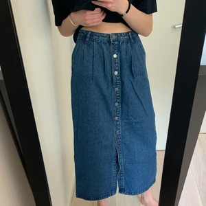 Lång jeanskjol - Lång jeanskjol med knappar längs hela framsidan, från NA-KD! Når ner till fotleden på mig som är ca 162 cm