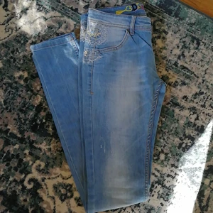 Desigual stuprörsjeans strl. 26 - Tajta strechjeans från Desigual med guldfärgade brodyrer och paljetter på bakfickorna. 