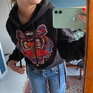 Kenzo hoodie - Jätte fin kenzo Hoodie.🧁 Har använts väldigt få gånger därför är den nästan i nyskick! Band som gör det möjligt att justera midjan. 🐶Köps i butik för ca 2000 men är ganska säker på den inte säljs längre (inte som jag hittat iallafall) kan mötas i Stockholm men kan även frakta (men då står köparen för frakten🐻‍❄️)