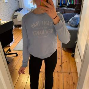 Sweatshirt från Gant i en fin ljusblå färg. Trycket är lite slitet men jag själv tycker det också är snyggt! Storlek XS