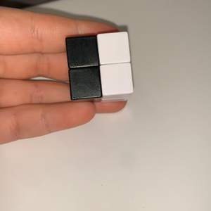 En svart vit rubixcub den är liten 