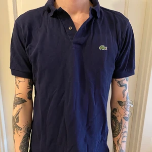 Lacoste pikétröja  - Kortarmad blå Lacoste piké! Super cool till vår/sommar ☀️ Har en del olika såna här - går att kombinera för rabatterad pris!