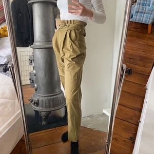 Paperbag byxor  - Superfina gröna högmidjade paperbag byxor från Mango i storlek 34/XS. Jag är 174 cm lång och de är som man kan se lite kortare i benen på mig. Superfint skick då jag endast använt dessa tre gånger.