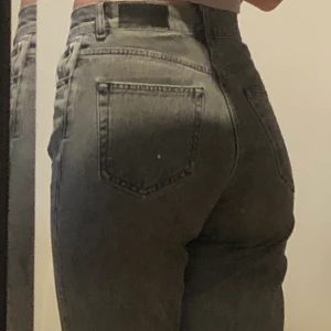 Bikbok jeans - Ett par högmidjade gråa bikbok jeans. 