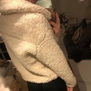 Vit Teddyjacka - En kort vit teddyjacka från ginatricot. Använd några gånger men väldigt fint skick. Knappar finns så den går att stänga om man vill det.