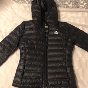 Adidas Dun Jacka - En jättefin adidas dunjacka som jag knappt använt pga att jag vuxit ur den, orginalpris 1300 och säljer för 800kr och jag står även för frakt. Jackan har 4 fickor 2 på utsidan och 2 på insidan. Priset kan även diskuteras STORLEK - Xs/XXs