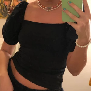 Svart T-shirt med puffärmar  - Snygg och skön topp i T-shirt material bortsett från dom pösiga puffärmarna i skjortmaterial. Tight passform, och mycket skön!