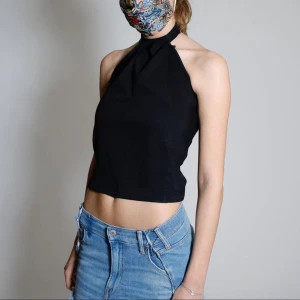 Lillan top - Svart halterneck top med knyte i nacken. Ursprungligen jeans från H&M som är omgjorda av Scannable UF. Genom att skanna en QR-kod som finns fäst på plagget kan du läsa mer om materialet och dess miljöpåverkan! ✨✨