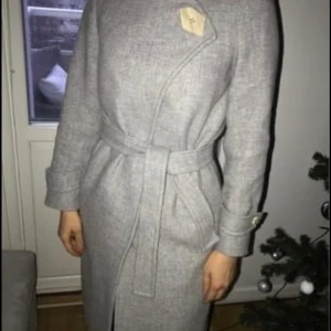 Snygg kappa  - Snygg och bra kappa i en fräsch ljusgrå färg med en snygg knappdetalj och bra passform. Jackan är köpt från Mango dyrt men säljer nu för endast 500kr