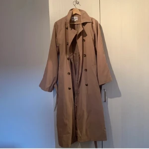 ursnygg trenchcoat  - Jättesnygg trenchcoat från NAKD, perfekt till våren! Köpt på plick men har köpt en ny nu så säljer denna. Fina band vid armarna som man kan knyta + band runt midjan 💕 Nypris är 999 fast säljer mycket billigare 💕 Passar många storlekar (xs-stort M) . Ej mina bilder. 