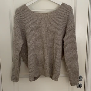 Beige stickad tröja med öppen rygg.  - Beige stickad tröja med jätte fin öppen rygg från NA-KD. Använd ett fåtal gånger och är i väldigt fint skick. 