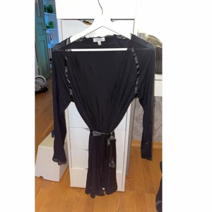 Morgonrock - Tunn svart morgonrock, svårt att visa på bild. Spetskanter och silkes band att knyta i midjan. Köpt i Frankrike för nåt år sen så vet ej märke. Knappt använd. Storlek S men passar xs-m 