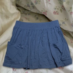 Logg kjol - vintage kjol från logg. Jätte fin blå färg (färgen lite svår att få upp på bild men är mer som andra bilden) men kommer tyvärr inte till användning. Barnstorlek 152 men passar XS/S/ Möjligtvis Liten M? Pågrund av stretchig resår band i midjan. Köparen står för frakt som tillkommer. 💙