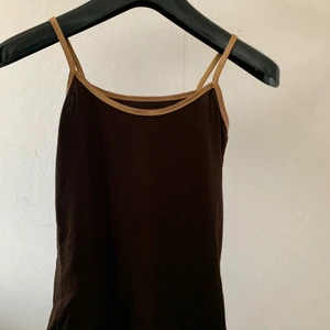 Brunt linne - Ett brunt linne med guld detaljer