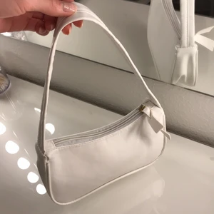 Vit baguette väska - Vit baguette väska av läder. Aldrig använd och är därför i väldigt bra skick. Fråga om ni undrar över måtten på väskan:)