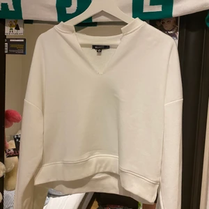 Vit sweatshirt  - Vit sweatshirt med v skuren detalj från missguided köpt på Nelly🤍 super fin, använd en gång så i bra skick! Säljer då den inte kommer till användning. Skriv vid frågor!😇🤍