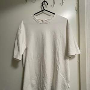 En vit t-shirt från COS i storlek XS. Lite oversize i modellen. Längre ärmar. Styvare material. 
