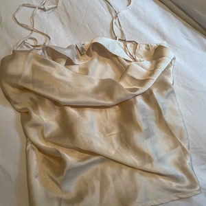 Satintopp - En fin festtopp i satin. Den sitter lite ”pösigt” vid brösten och banden är korsade i ryggen. Säljer då den inte passar mig. Den är storlek 36 men är mer som en 38 eller M enligt mig💙 köpare står för frakt 