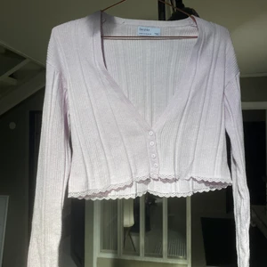 Crop top med knappar - Crop top med långa armar som är helt ny. Tyget är väldigt mjukt. Toppen är ljust pastellila, vilket syns bäst på andra bilden. 
